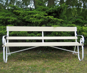 Cream coloured wrought iron and wood garden bench